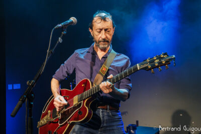 Un des chanteurs du groupe Les Innocents joue de la guitare sur la scène du Virtuoz club de Villeneuve-la-Garenne - Agrandir l'image 1 sur 6, fenêtre modale