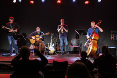 Trois professeurs de l'école de musique de Villeneuve-la-Garenne jouent de la guitare, de la contrebasse et de la trompette pour la masterclass mes indispensables du jazz, sur la scène du Virtuoz club. - Agrandir l'image 2 sur 6, fenêtre modale