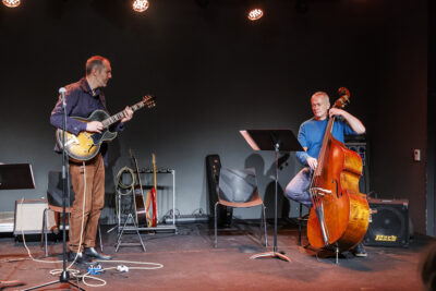 Deux professeurs de l'école de musique de Villeneuve-la-Garenne jouent de la guitare et de la contrebasse pour la masterclass mes indispensables du jazz, sur la scène du Virtuoz club. - Agrandir l'image 1 sur 6, fenêtre modale