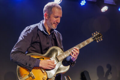 Un professeur de l'école de musique de Villeneuve-la-Garenne joue de la guitare pour la masterclass mes indispensables du jazz, sur la scène du Virtuoz club. - Agrandir l'image 5 sur 6, fenêtre modale