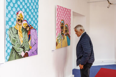 Un homme regarde les tableaux de l'artiste Jules Be Kuti lors du vernissage de l'exposition qui lui est consacré à Villeneuve-la-Garenne.