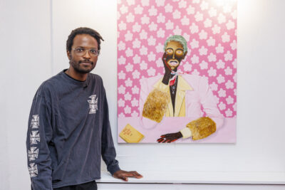 L'artiste Jules Be Kuti pose devant un de ses tableaux lors du vernissage de l'exposition qui lui est consacrée à Villeneuve-la-Garenne - Agrandir l'image 6 sur 6, fenêtre modale