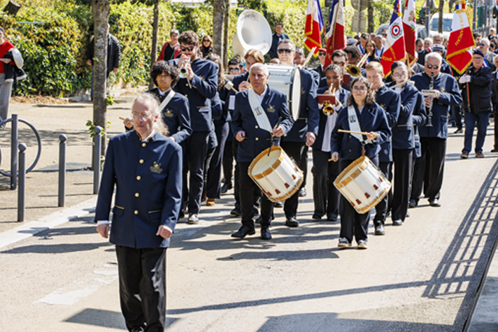 Cortège mené par l'orchestre d'harmonie de l'école de musique de Villeneuve-la-Garenne, composé d'ancien combattants, d'élus et d'habitants pour la commémoration du 8 mai 1945.