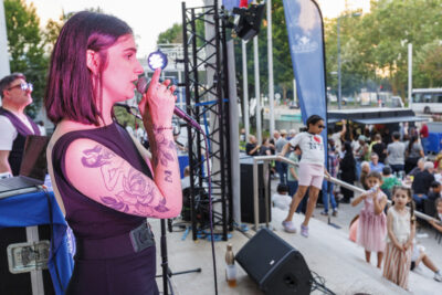 La chanteuse Ambriel tient le micro et chante dans le cadre de la soirée food trucks et musique - Agrandir l'image 6 sur 6, fenêtre modale