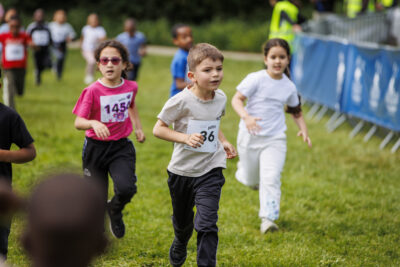 Plusieurs élèves des écoles de Villeneuve-la-Garenne sont en train de courir pour la course Mil'Pattes dans un parc de la ville. - Agrandir l'image 4 sur 6, fenêtre modale