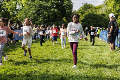 Plusieurs élèves des écoles de Villeneuve-la-Garenne sont en train de courir pour la course Mil'Pattes dans un parc de la ville. - Agrandir l'image 2 sur 6, fenêtre modale