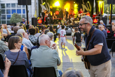 Un homme du groupe malted milk joue de la guitare avec le public pour le festival Villeneuve Jazz. - Agrandir l'image 3 sur 6, fenêtre modale