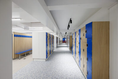 Un vestiaire moderne avec des casiers en bois et bleu, accompagné de bancs. - Agrandir l'image 2 sur 7, fenêtre modale