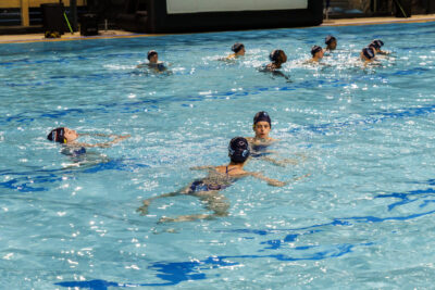Des nageurs et nageuses en bonnet dans une piscine, participant à une activité collective. - Agrandir l'image 1 sur 7, fenêtre modale