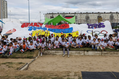 Des enfants d'accueils de loisirs tiennent une bâche en l'honneur des Jeux Olympiques. - Agrandir l'image 4 sur 6, fenêtre modale