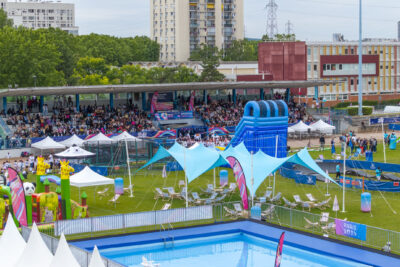 Stade avec des structures gonfables une piscine et du monde dans les tribunes - Agrandir l'image 1 sur 6, fenêtre modale