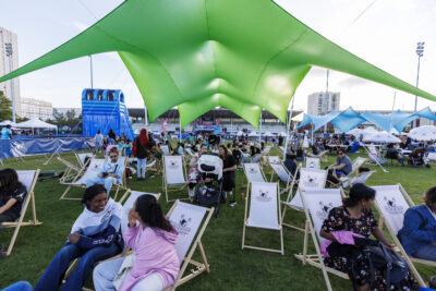 Plusieurs personnes sont assises sur des transats sur un stade. - Agrandir l'image 6 sur 6, fenêtre modale