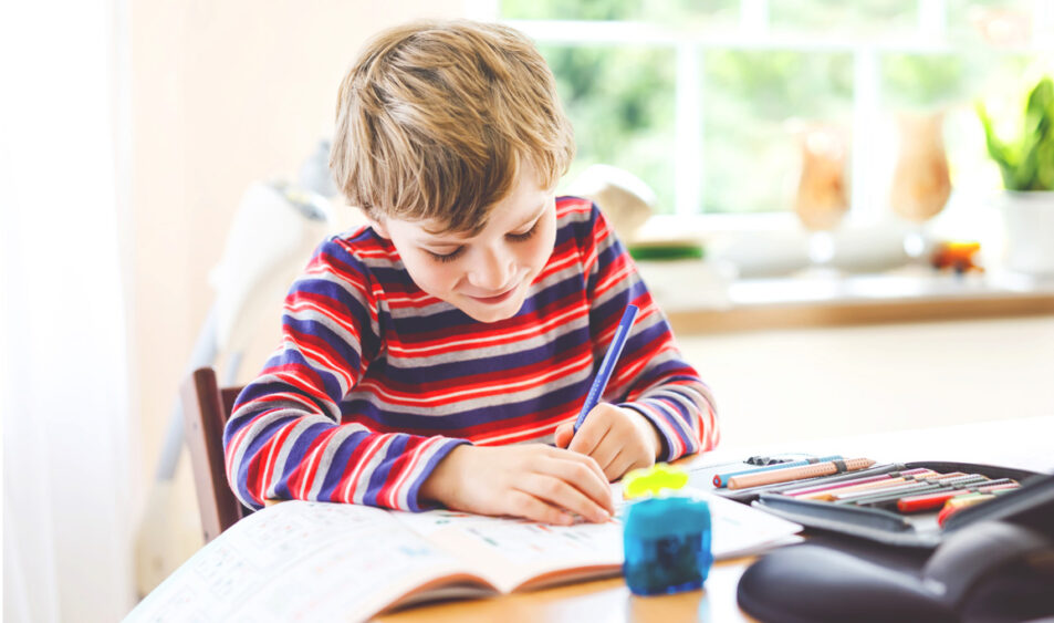 Petit garçon qui est en train d'écrire sur un cahier