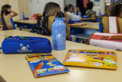 Gourde, trousse et des crayons de couleurs sur une table de classe - Agrandir l'image 6 sur 6, fenêtre modale