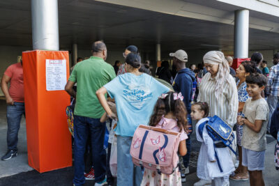 Des parents et des enfants regardent les listes des classes dans une cour d'école - Agrandir l'image 4 sur 6, fenêtre modale