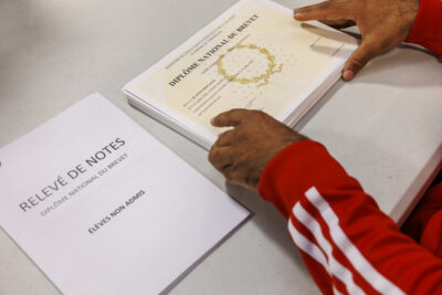 Un tas de diplôme brevet des collèges tenu par des mains - Agrandir l'image 1 sur 6, fenêtre modale