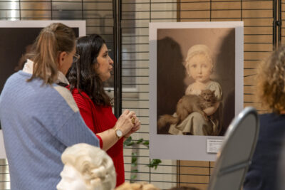 Une médiatrice explique une exposition de portraits - Agrandir l'image 2 sur 6, fenêtre modale