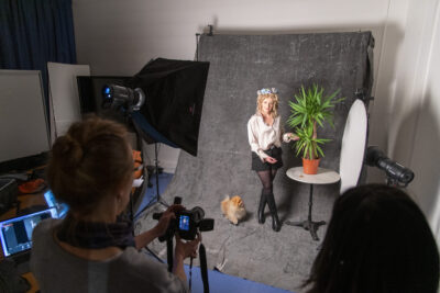 Une femme prend la pose avec son chien elle tient une plante et une autre femme la prend en photo - Agrandir l'image 6 sur 6, fenêtre modale