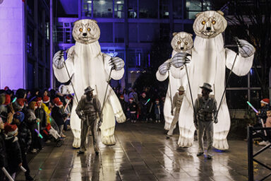 3 hommes portent des ours blanc illuminés et se balade dans la rue