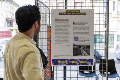 Un homme regarde un panneau d'exposition sur la seconde guerre mondiale - Agrandir l'image 6 sur 6, fenêtre modale