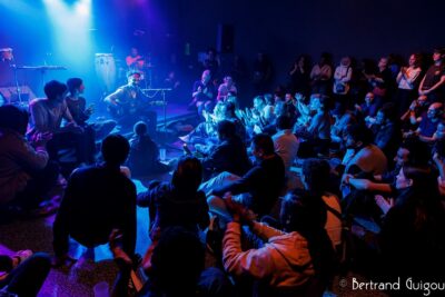 Le chanteur David Walters est assis sur scène avec sa guitare et un micro il se produit sur la scène du Virtuoz club à Villeneuve-la-Garenne - Agrandir l'image 1 sur 6, fenêtre modale