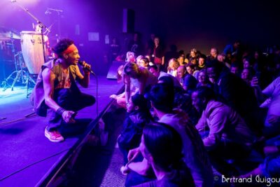 Le chanteur David Walters est assis auprès du public tout en chantant au Virtuoz club de Villeneuve-la-Garenne - Agrandir l'image 6 sur 6, fenêtre modale