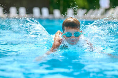 Un enfant portant des lunettes de plongée dans une piscine