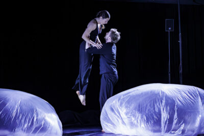 La danseuse est suspendue dans les bras de son partenaire dans un univers sombre  - Agrandir l'image 2 sur 6, fenêtre modale